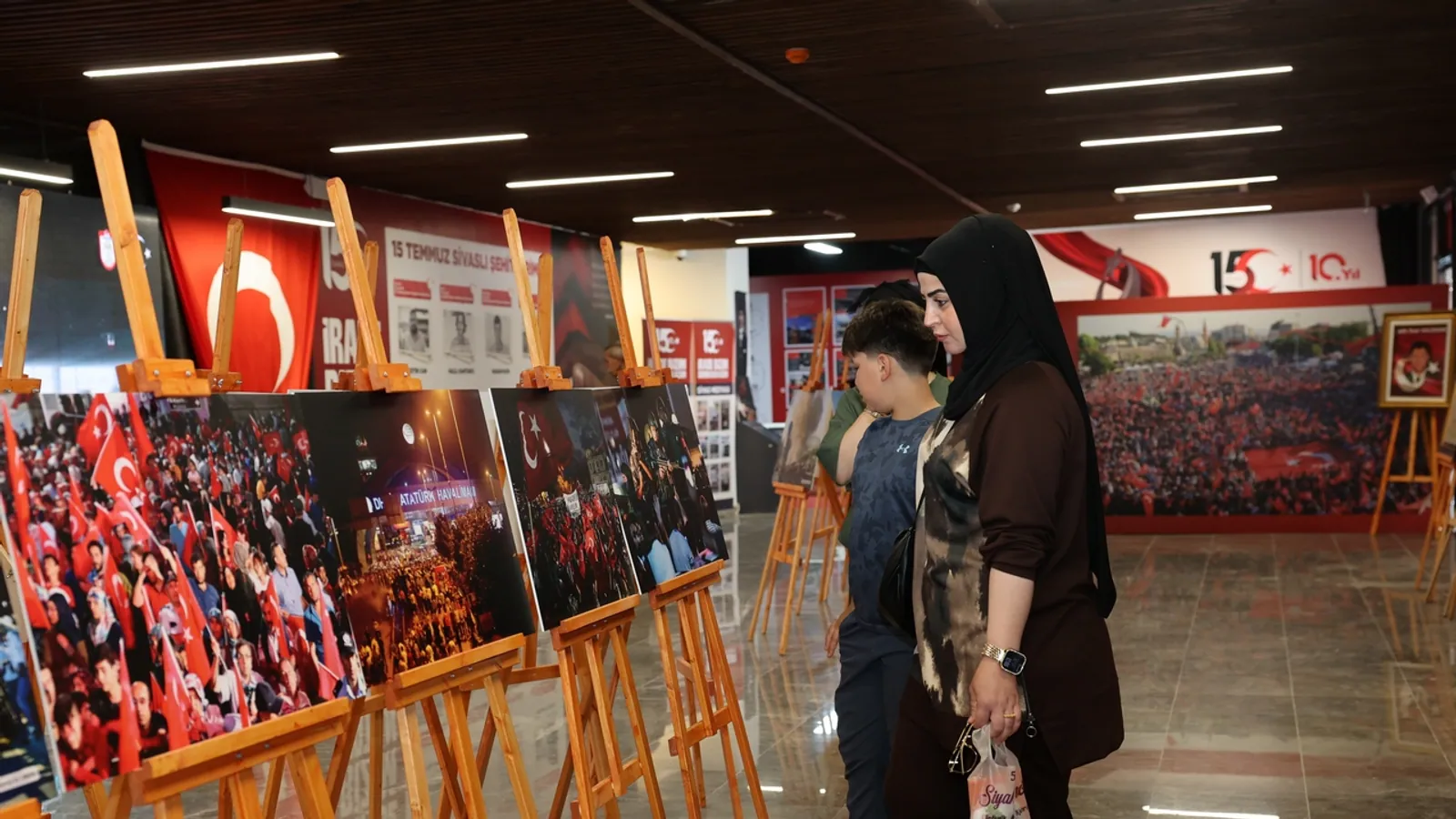 Sivas 15 Temmuz Anı Merkezi'ndeki fotoğraf ve gazete kupürü sergisini inceleyen ziyaretçiler
